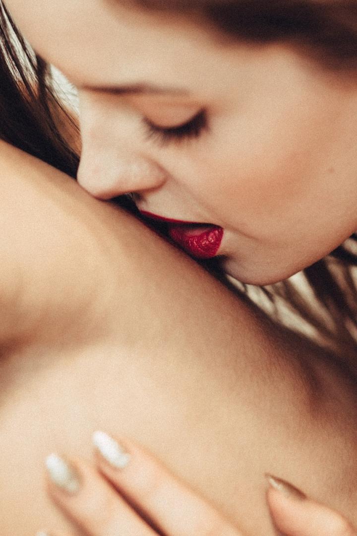 Frau liegt auf dem Oberkörper eines Mannes und küsst seine Brust