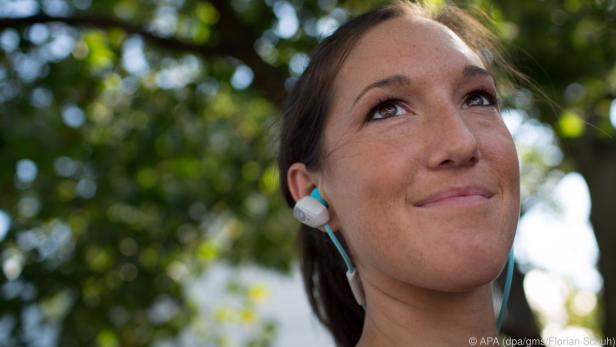 Sportler sind mit Wireless-Ohrhörern mit Kabel im Nacken stressfrei unterwegs Sportler sind mit Wireless-Ohrhörern mit Kabel im Nacken stressfrei unterwegs