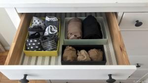 Socken und Strumpfhosen werden in Schachteln in einer Schublade verstaut