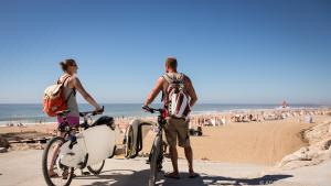 Surf-Mekka: Wellenreiter mit Rad am Strand Praia Grande in Portugal