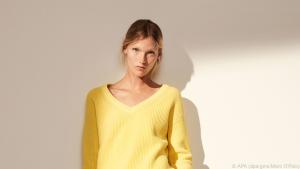 Zu gebräunter Haut passen knallige Farben - wie dieser gelbe Pulli
