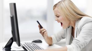 angry woman with smart phone and computer screaming curses