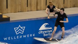 Mit Hilfestellung: Der erste Stehversuch auf dem Surfbrett