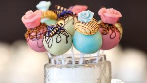 Bunte Vanille Cake-Pops bekommen durch Verzierungen das i-Tüpfelchen verpasst