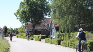Touristen kurven mit Fahrrädern durch die Gassen von Wieck am Darß