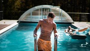Trainierter Mann steigt aus Pool