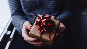 Eine Frau hält ein Weihnachtsgeschenk mit Schleife