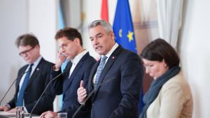 Bundeskanzler Nehammer und weitere Politiker stehen vor Mikrofonen bei einer Pressekonferenz