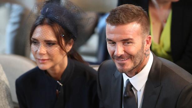 Victoria und David Beckham sitzen nebeneinander auf einer Tribüne
