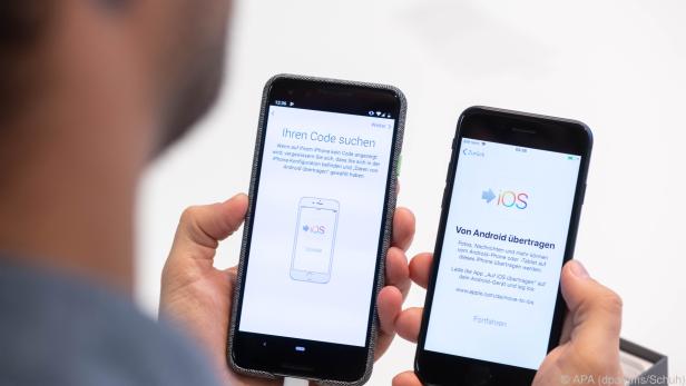 Android links, iOS rechts, dazwischen ein Datenübertragungskabel