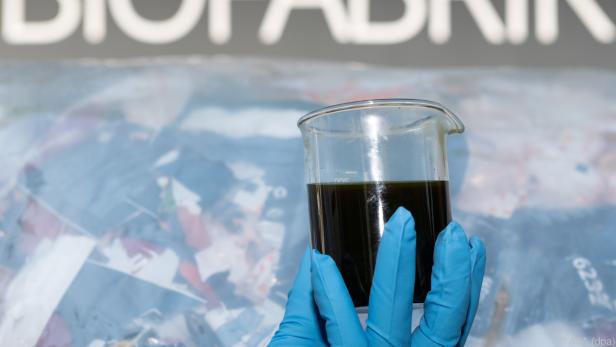 Ein Glas mit aus Plastik wiederverwerteten Öl