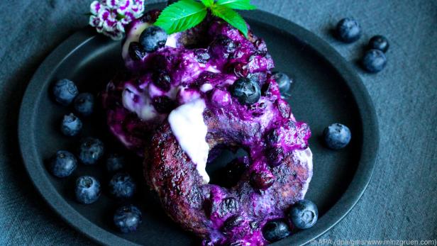 Die Donuts werden im Saft der Heidelbeeren gewendet und mit Joghurt serviert