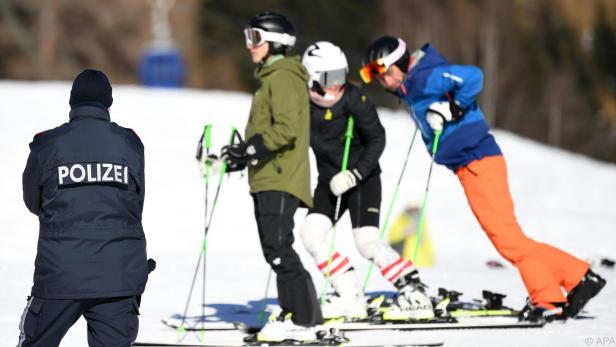 Polizei und Wintersportler auf einer Skipiste