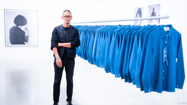 Künstler Huang Po-Chih neben blauen Jeanshemden im mumok