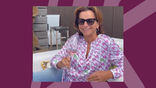 Brünette Frau mit Sonnenbrille und einem Glas Wein im Whirlpool