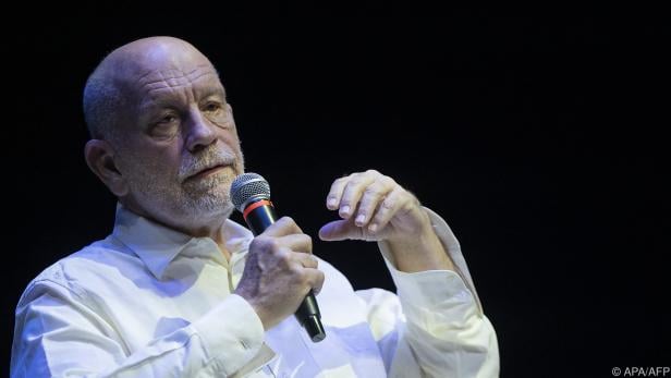 John Malkovich nimmt auf der berühmten Couch Platz