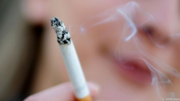 Eine junge Frau raucht eine Zigarette.  