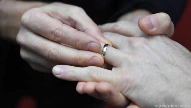 Person steckt einen Ring an den Finger einer anderen Hand