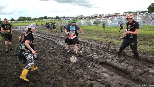 Festival-Besucher machen das beste aus dem schlammigen Festivalgelände