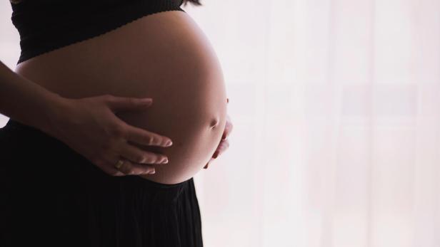 Eine Frau zeigt ihren nackten Babybauch