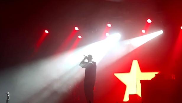 Konzertfoto von Rapper Disarstar mit rotem Stern im Bühnenbild