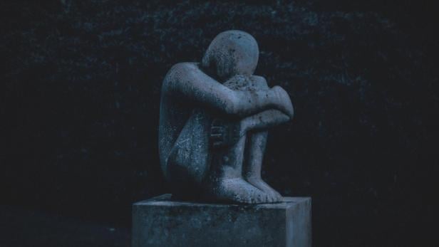 Depression und Schuld: Dargestellt in einer kauernden Statue.
