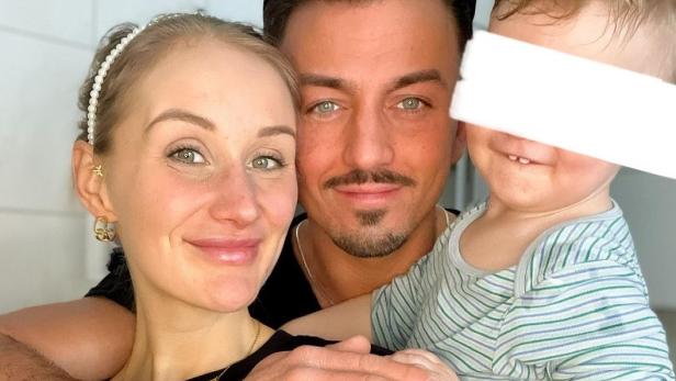 Junges Paar posiert zusammen mit kleinem Sohn für ein Selfie